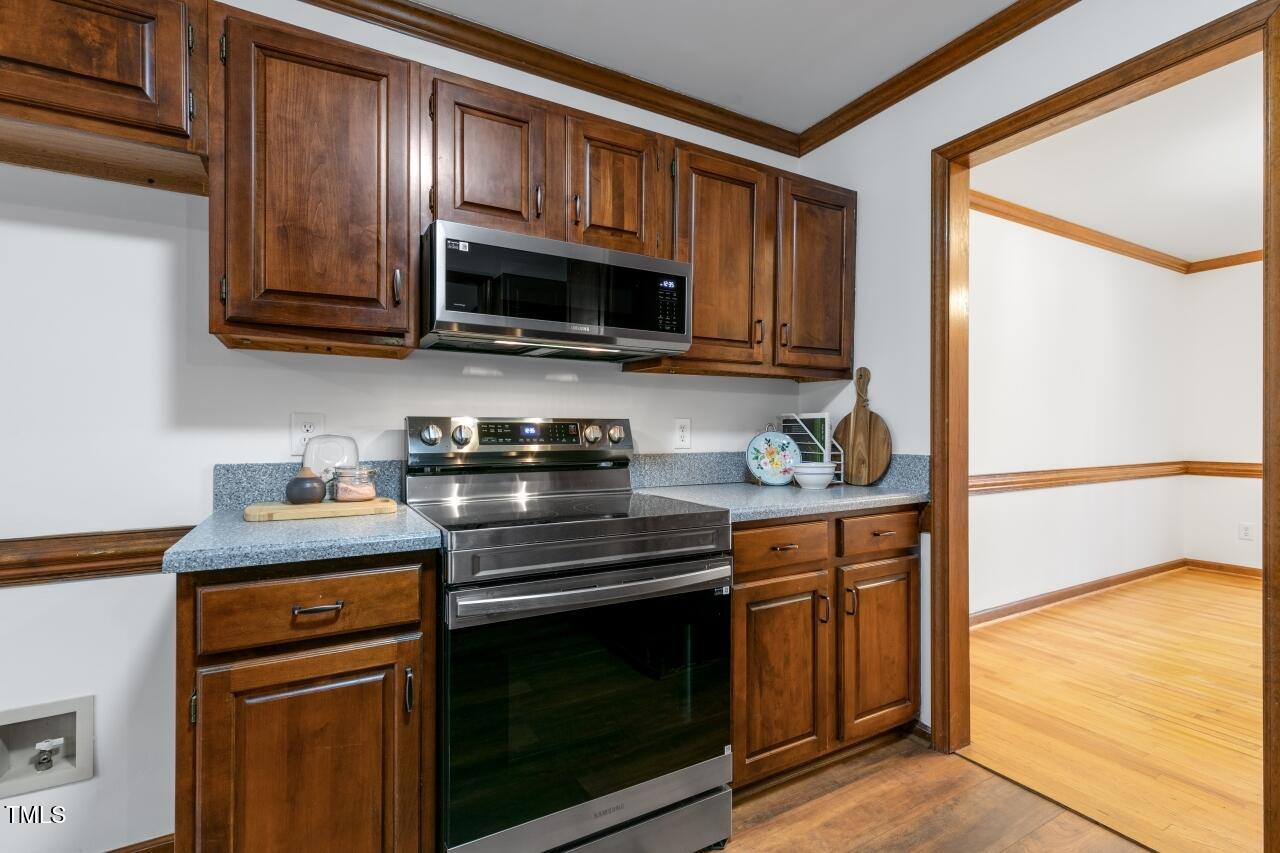 112 Ridgepath Way Cary, NC 27511 - Photo 14 of 38 a kitchen with stainless steel appliances granite countertop wooden cabinets and a stove top oven