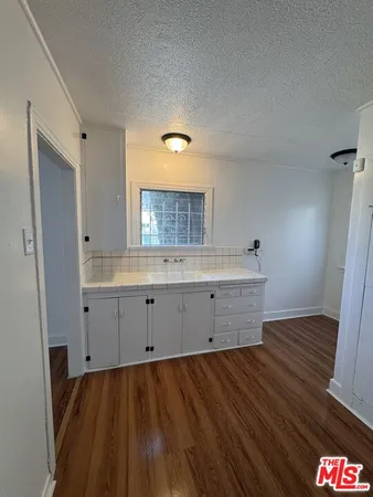 a view of kitchen and empty room with window