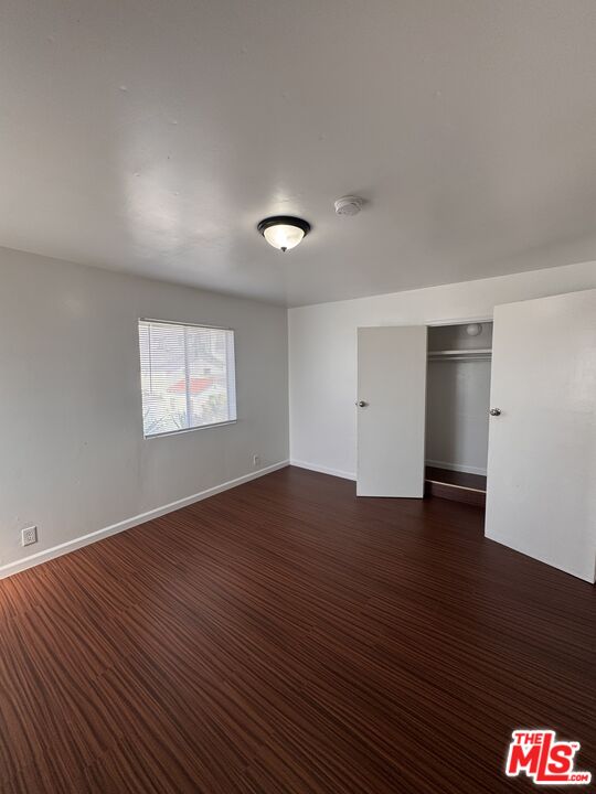 1650 South Rimpau Boulevard Los Angeles, CA 90019 - Photo 6 of 12 an empty room with wooden floor and windows