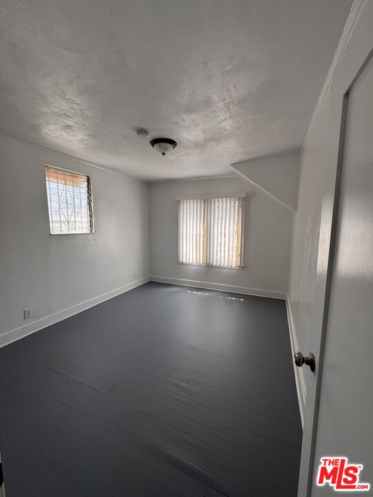 1650 South Rimpau Boulevard Los Angeles, CA 90019 - Photo 9 of 12 an empty room with windows and stairs