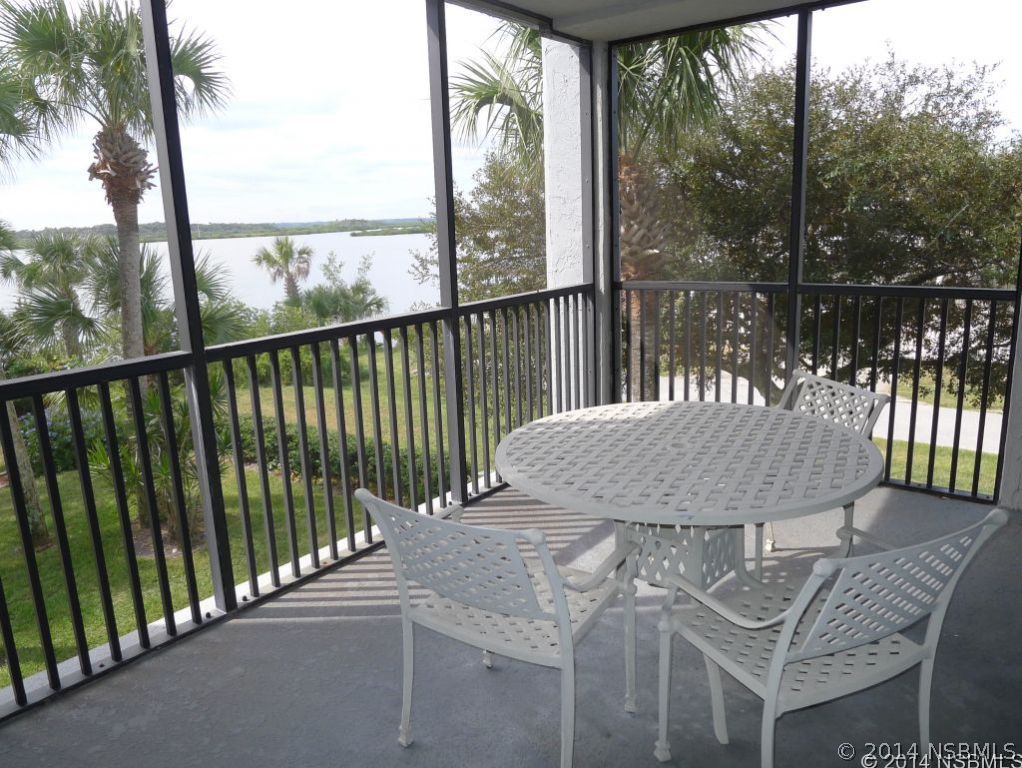 6544 Engram Road, Unit E204 New Smyrna Beach, FL 32169 - Photo 11 of 22 a view of a balcony with floor to ceiling window and wooden fence