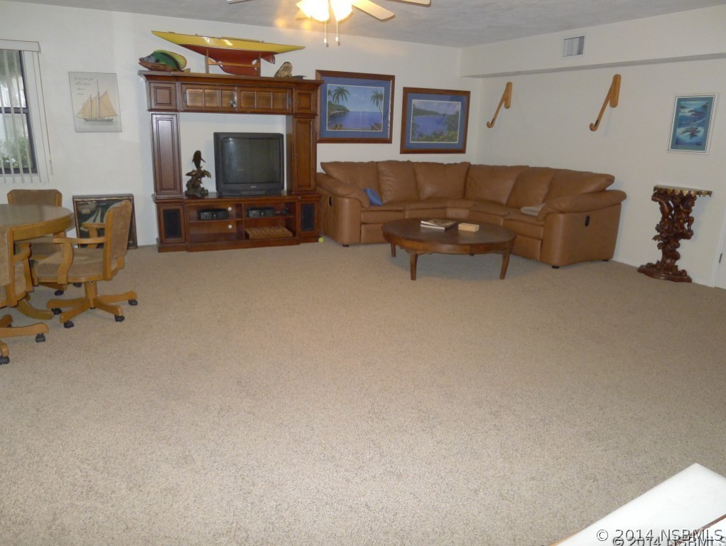 6544 Engram Road, Unit E204 New Smyrna Beach, FL 32169 - Photo 18 of 22 a living room with furniture and a fireplace