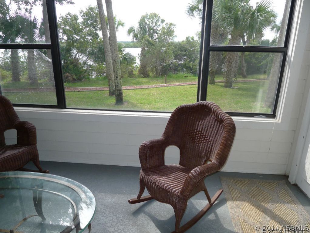 6544 Engram Road, Unit E204 New Smyrna Beach, FL 32169 - Photo 19 of 22 a living room filled with furniture and a floor to ceiling window