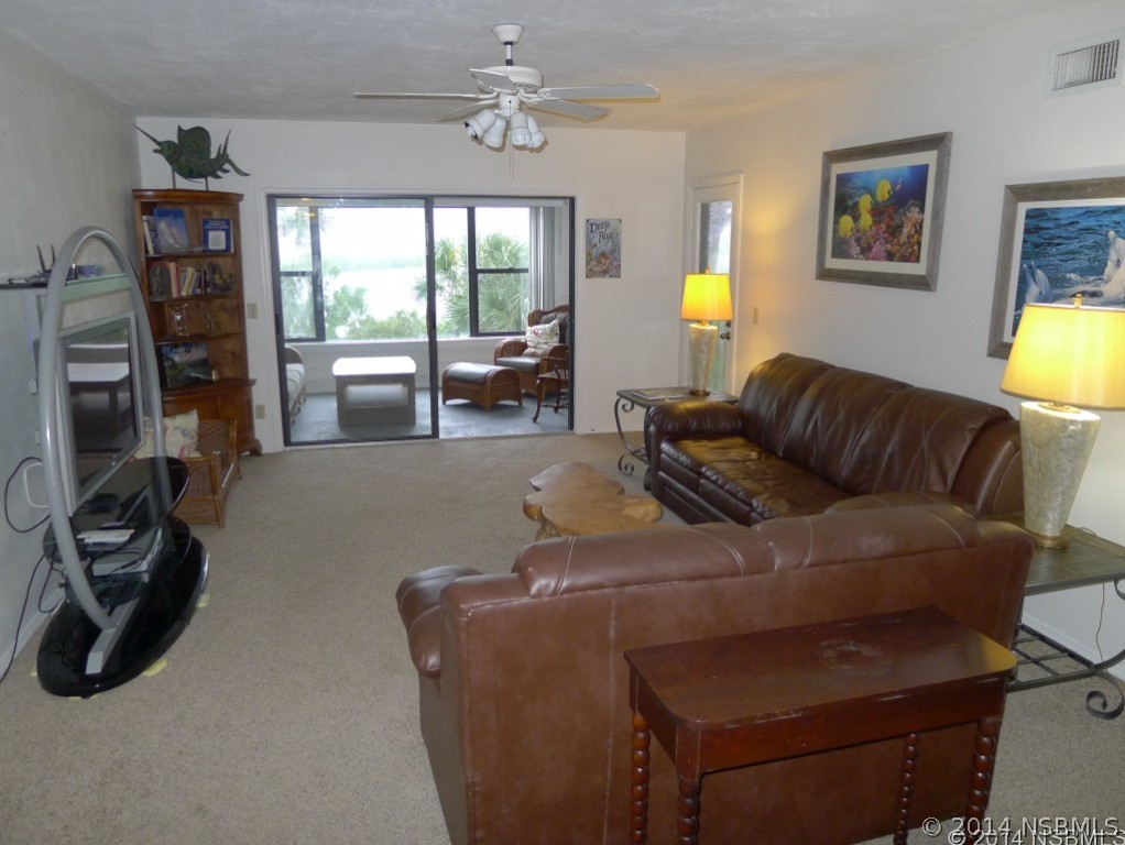 6544 Engram Road, Unit E204 New Smyrna Beach, FL 32169 - Photo 6 of 22 a living room with furniture and a flat screen tv