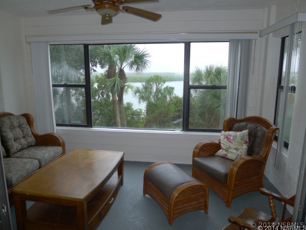 6544 Engram Road, Unit E204 New Smyrna Beach, FL 32169 - Photo 9 of 22 a living room with furniture and a floor to ceiling window