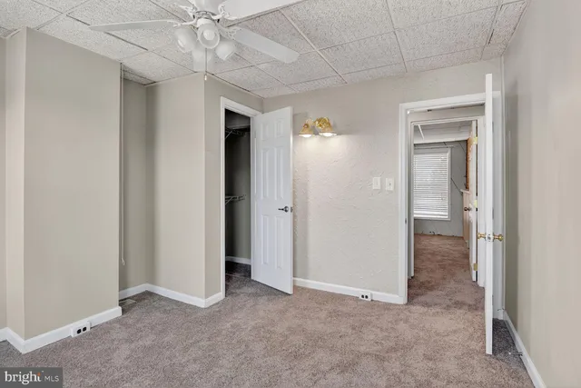 an empty room with a ceiling fan and a bathroom