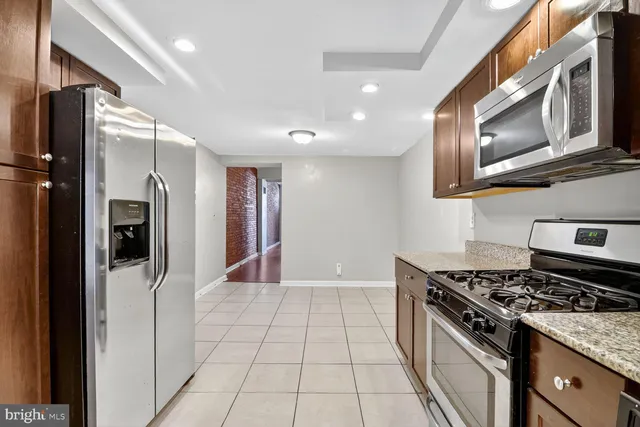 a kitchen with stainless steel appliances granite countertop a stove a refrigerator and a microwave