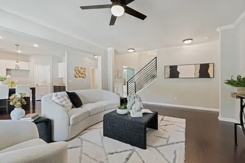 a living room with furniture and a ceiling fan
