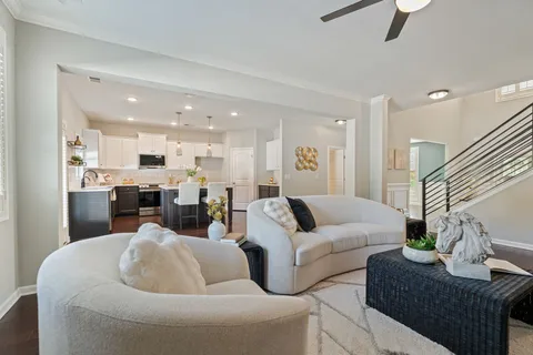 a living room with furniture kitchen view and a chandelier