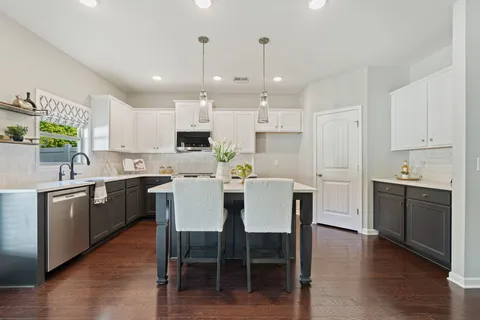 a kitchen with a dining table chairs stainless steel appliances and cabinets