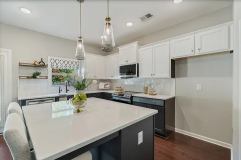 a kitchen with stainless steel appliances a white table chairs and a refrigerator