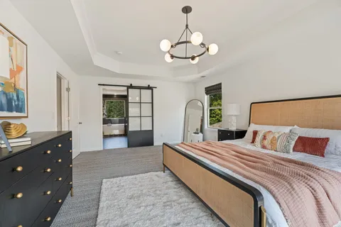 a bedroom with a large bed and a chandelier