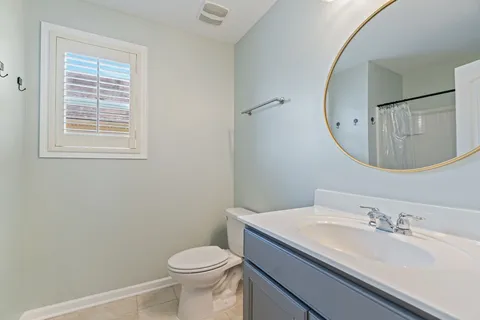 a bathroom with a granite countertop sink mirror vanity and toilet