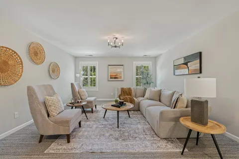 a living room with furniture a rug and a window