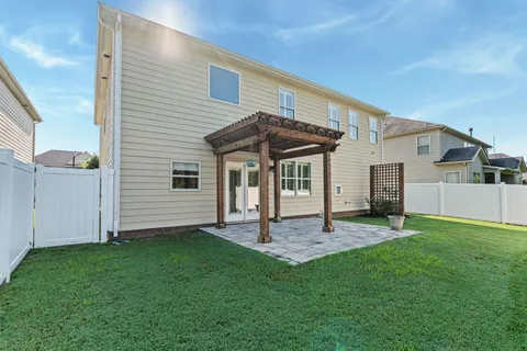 a view of a house with backyard and a patio