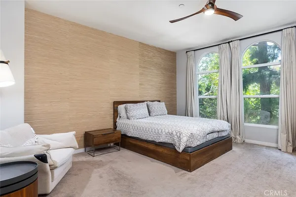 a spacious bedroom with a bed and glass window