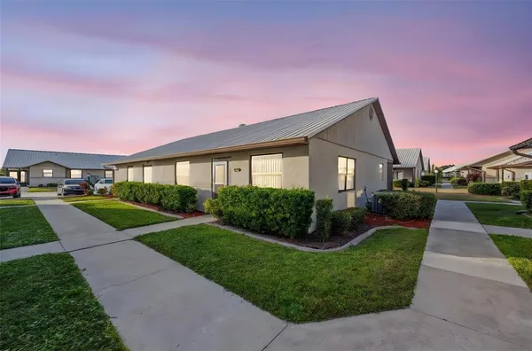 a front view of a house with a yard and potted plants