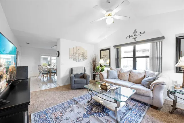 a living room with furniture a flat screen tv and a window