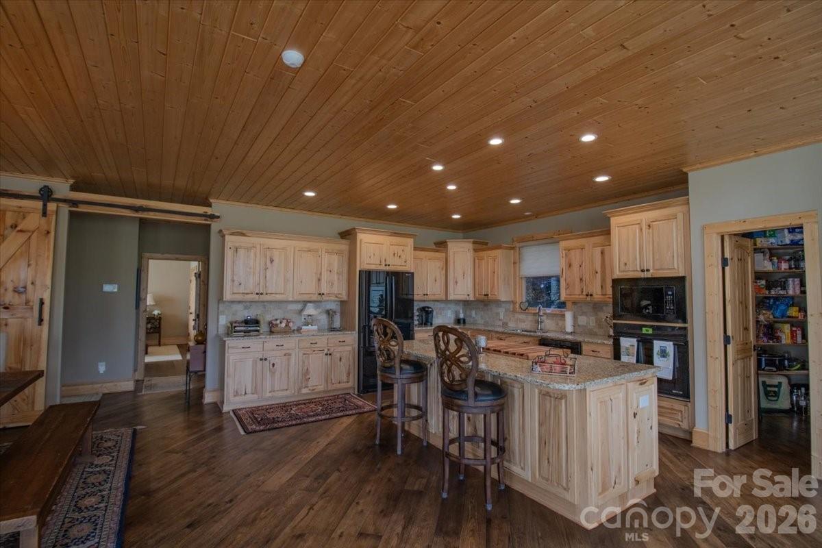 1083 Union Community Road Thurmond, NC 28683 - Photo 9 of 47 a kitchen with stainless steel appliances kitchen island granite countertop a refrigerator oven a sink a dining table and chairs with wooden floor