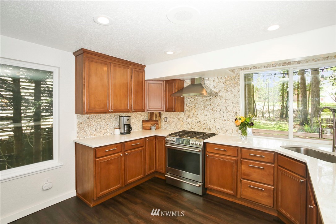 218 221st Street Southwest Bothell, WA 98021 - Photo 11 of 40 a kitchen with stainless steel appliances granite countertop wooden cabinets a stove a sink and a large window
