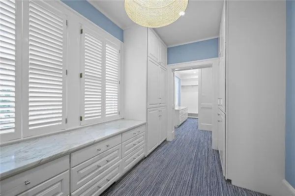 a view of a hallway with wooden floor and windows