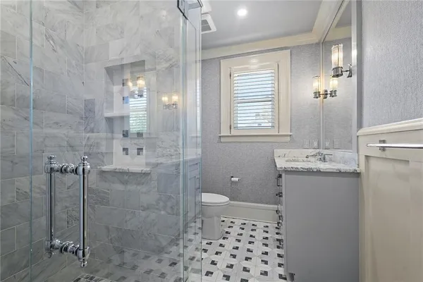a bathroom with a granite countertop sink a large mirror and a bathtub next to a window