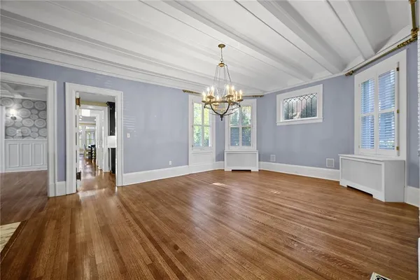 a view of a livingroom with a fireplace a chandelier and wooden floor