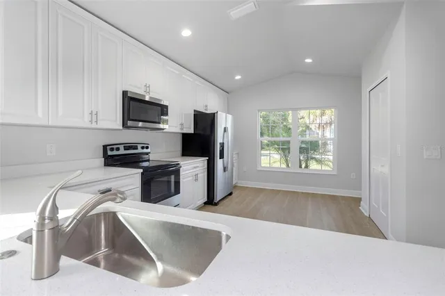 a kitchen with a sink a microwave and cabinets