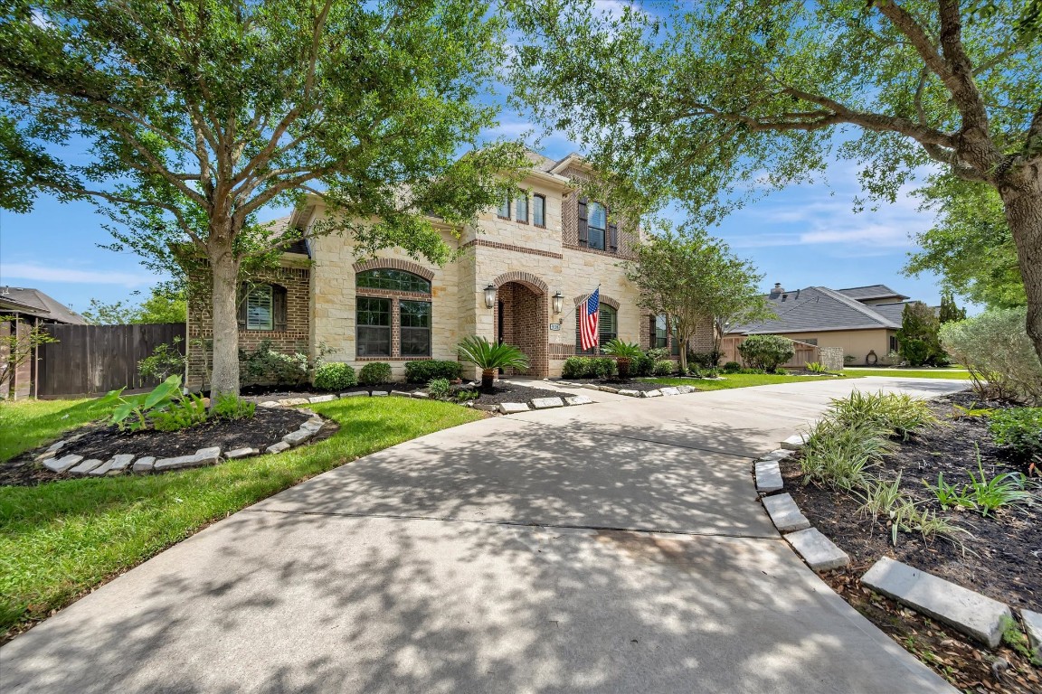 a front view of a house with a garden and trees