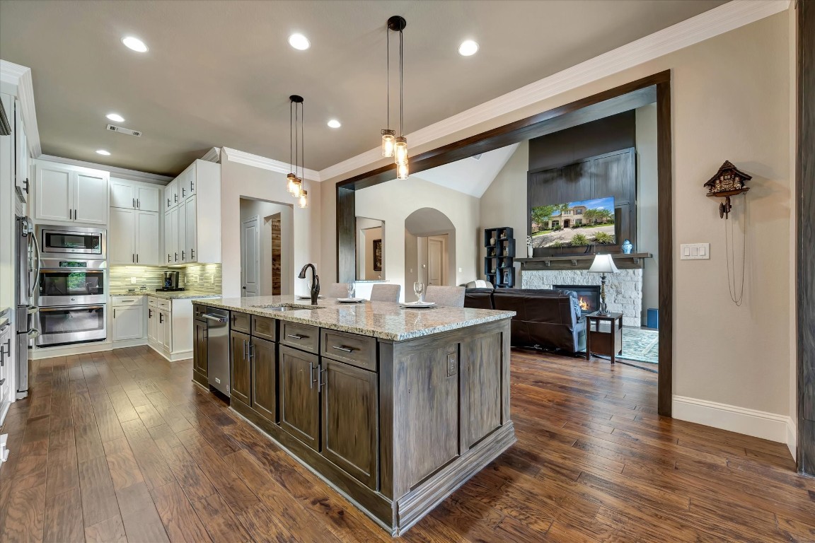 3108 Tyler Court Friendswood, TX 77546 - Photo 15 of 50 a kitchen with kitchen island granite countertop a sink cabinets and wooden floor