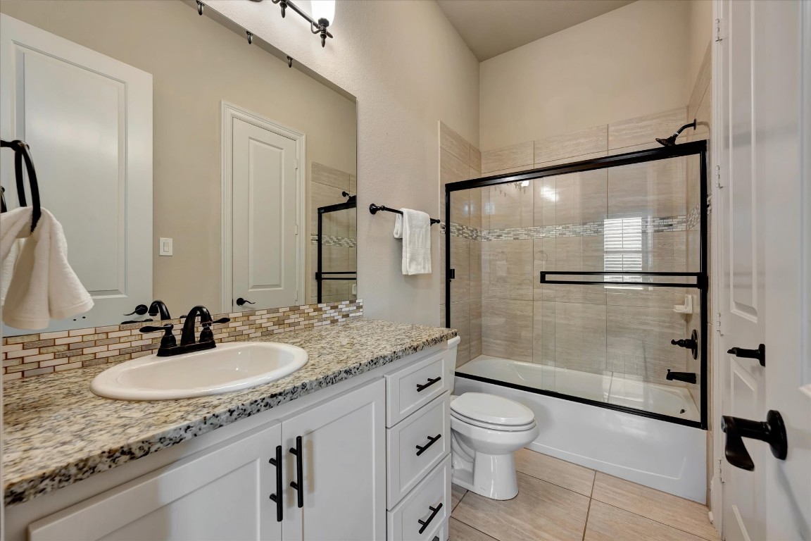 3108 Tyler Court Friendswood, TX 77546 - Photo 24 of 50 a bathroom with a granite countertop sink toilet a mirror and shower