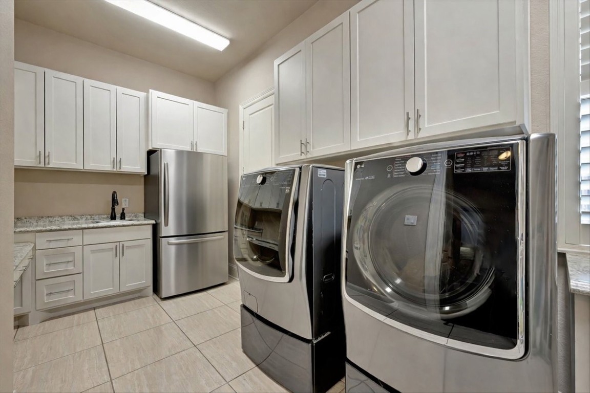3108 Tyler Court Friendswood, TX 77546 - Photo 29 of 50 a kitchen with stainless steel appliances granite countertop a refrigerator a washer and dryer