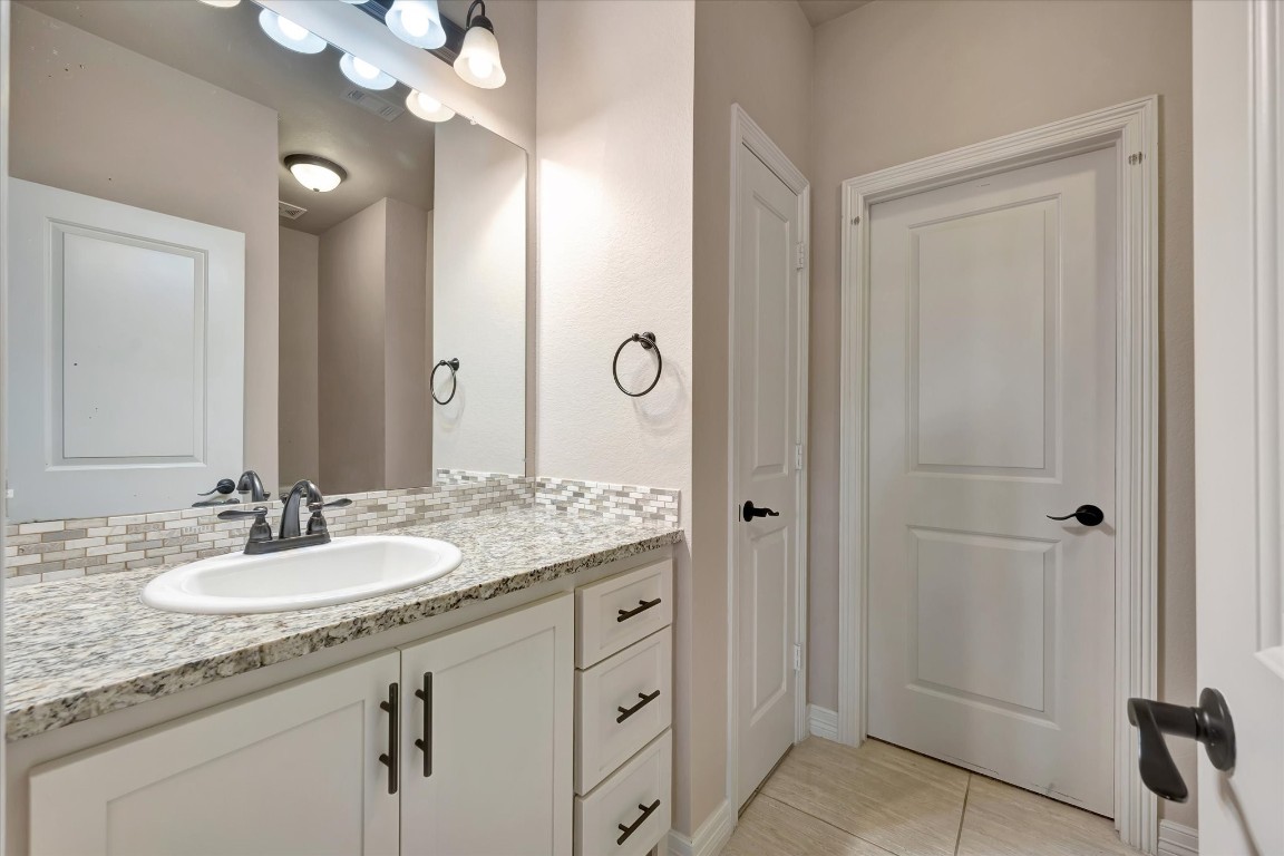 3108 Tyler Court Friendswood, TX 77546 - Photo 36 of 50 a bathroom with a granite countertop sink two mirror and shower
