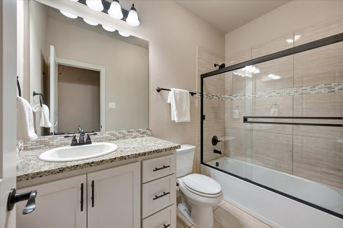 3108 Tyler Court Friendswood, TX 77546 - Photo 38 of 50 a bathroom with a granite countertop sink a toilet and shower