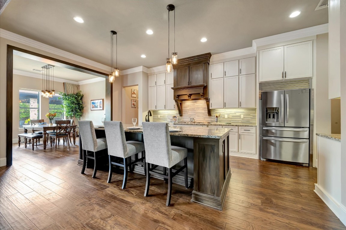 3108 Tyler Court Friendswood, TX 77546 - Photo 5 of 50 a kitchen with stainless steel appliances kitchen island granite countertop a refrigerator a stove a kitchen island with a dining table and chairs