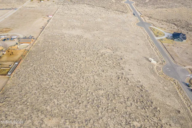 a view of a dry yard with wooden fence