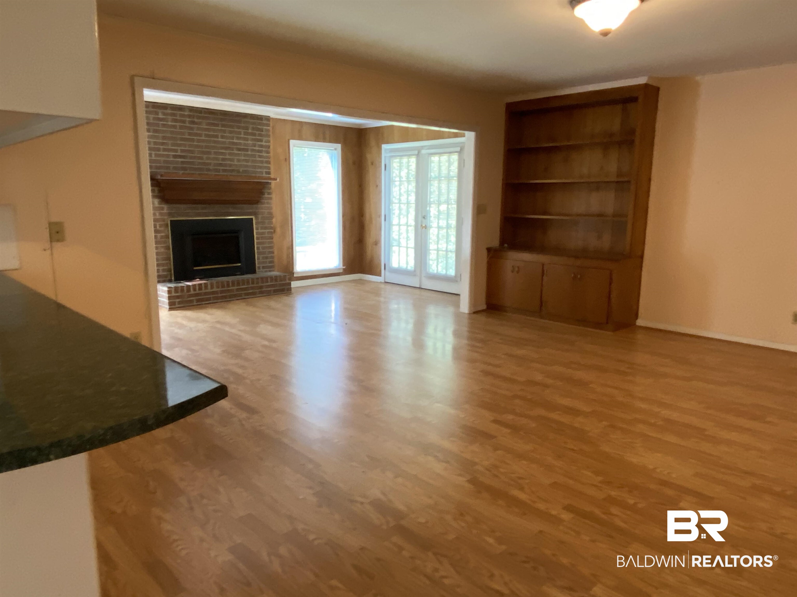 106 Terry Drive Brewton, AL 36426 - Photo 9 of 25 Unfurnished Den with light wood-style floors, a brick fireplace, french doors, and built in features