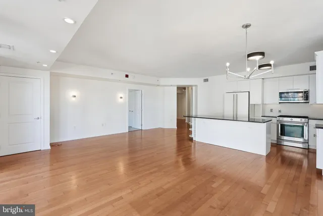 a kitchen with stainless steel appliances granite countertop a refrigerator and a stove top oven
