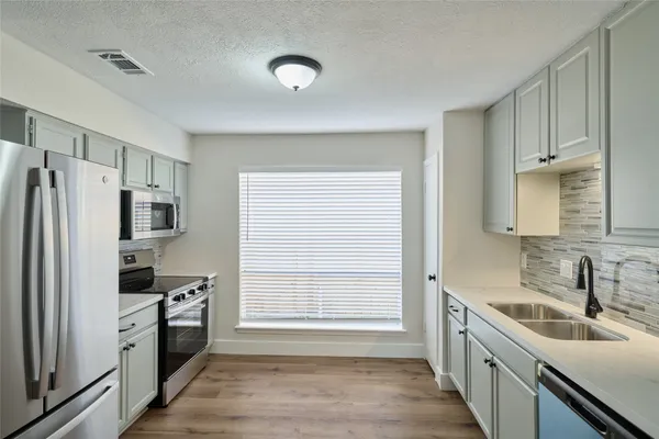 a kitchen with a refrigerator stove and sink
