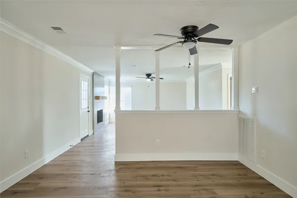 a view of a big room with wooden floor and windows