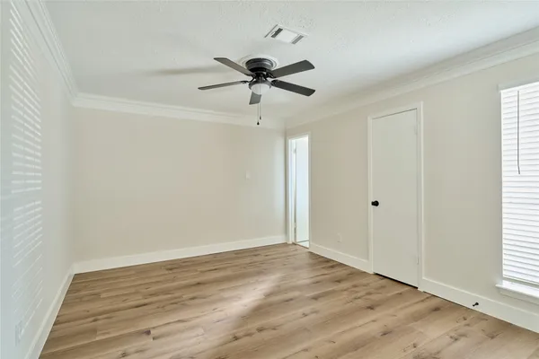 a view of empty room with wooden floor and ceiling fan