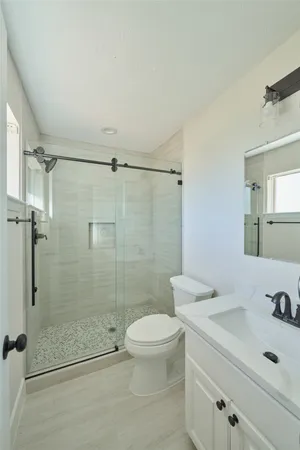 a bathroom with a sink a toilet and shower