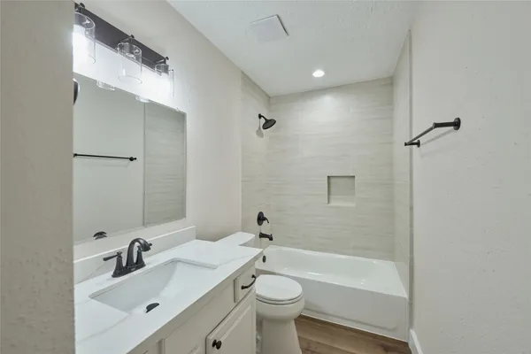 a bathroom with a sink mirror toilet and bathtub