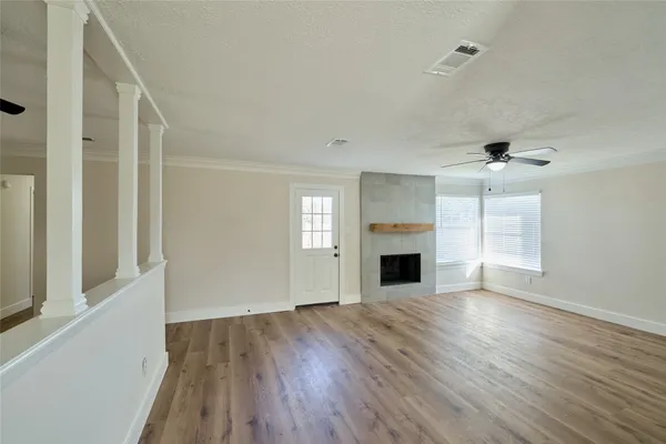 wooden floor fireplace and windows in an empty room
