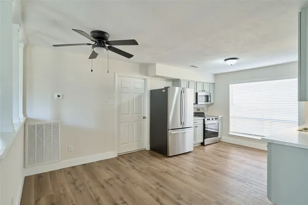 a view of empty room with wooden floor and window