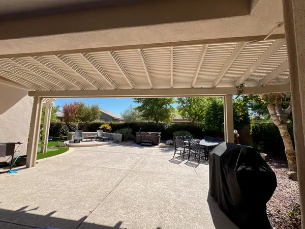a view of a patio with a table and chairs under an umbrella with a tub