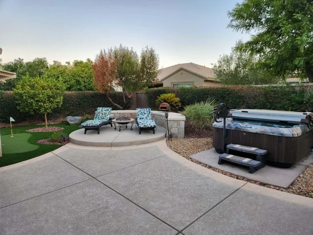 a view of patio with table and chairs potted plants and a palm tree