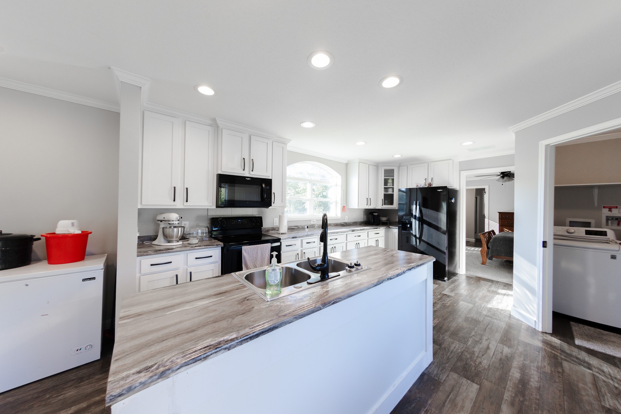 307 Swiss Colony Road Hohenwald, TN 38462 - Photo 7 of 35 a kitchen with stainless steel appliances kitchen island granite countertop a sink dishwasher stove and refrigerator with wooden floor