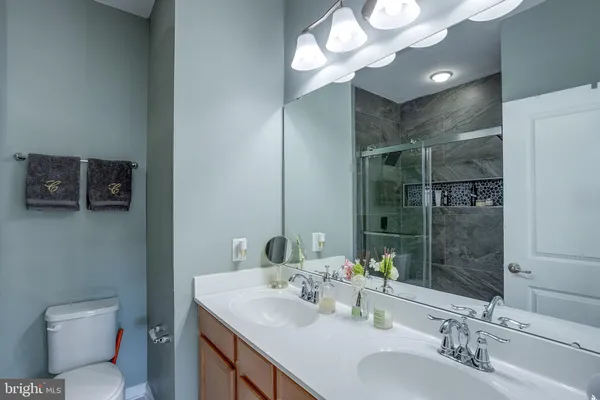 a bathroom with a sink a toilet and a mirror