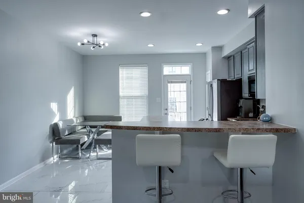 a kitchen with stainless steel appliances granite countertop a sink and chairs